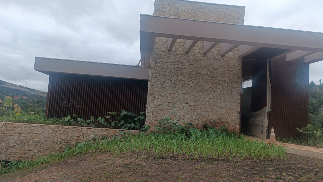 Fachada com revestimento em pedra natural e brises de madeira